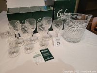 Seven Galway Irish Crystal wine glasses and one Leah wine cooler displayed with original Galway Irish Crystal boxes and informational pamphlets.