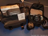 Overview of Canon ES400V camcorder in soft case, Sony a6000 with lens in soft case, two lenses on table