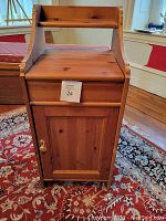 Front view of the wooden side table showing drawer and closed cabinet door with stop sign card 24 attached
