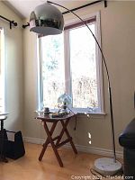 Full view of arched chrome floor lamp with dome shade in room