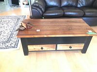 Front view of coffee table with drawers closed and small items on top