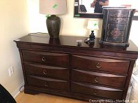 Front view of six-drawer dresser showing ring pulls and dark brown wood finish