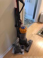 Front angle showing full upright vacuum with hose and attached handle