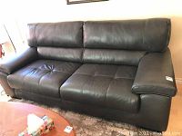 Front view of dark grey leather couch in living room