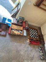 Wide view of lot showing various boxed board games and wooden game boards including chess and backgammon.
