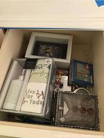 Photo including hip flask, shadow box frame, and boxed bathroom set in drawer