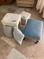Full view of three footstools and three decorative pillows on tiled floor.