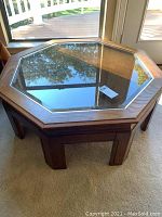 Full view of the octagonal wooden coffee table with glass top insert.