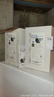 Two boxed Ductworx air purification systems on a white surface against a basement wall, one box sealed, the other open, showing product image and brand.