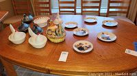 Photo showing full lot of ceramic chickens, rooster, dishes, and Norman Rockwell plates on a wooden table.