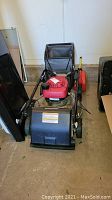Front view of mower showing deck, engine and grass collection bag