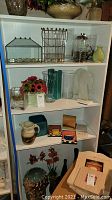 Shelf of various glass and ceramic vases, signed pottery pitcher, decorative tiles, book ends, and faux floral arrangement