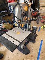 Full view of band saw showing table, blade, and yellow adjustment knobs.