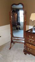 Full frontal view of the wooden cheval mirror showing the arched top and wooden spindle frame design.
