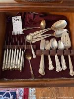Full set of Rogers silverplate flatware arranged in drawer with felt lining. Includes carving utensils, serving spoons and forks, and forks and spoons of various sizes.
