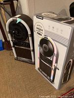 Photo showing the Art+Sound LED wireless jukebox record player next to its original branded box.