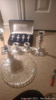 Cake plate with rose motif and four silver plated candle holders on carpet