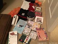 Overview photo showing candles, hats, mittens, stationery items, books, cheese signs, corkscrew, coasters and lint remover.