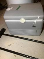 Front and top view of the grey Igloo Koolmate 32 electric cooler showing the latch and exterior condition.