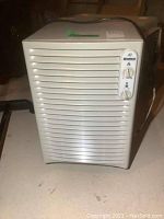 White Kenmore dehumidifier rectangular unit with vent slats and rotary control knobs on front