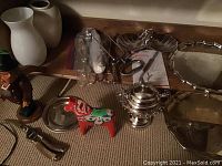 Wide view of lot showing trays, utensils, painted horse, silver pot, nutcracker