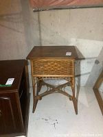 Full view of rattan side table showing woven texture and wooden lift-top