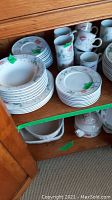 Stacked dinner plates, luncheon plates, soup bowls and cups in Albertina pattern on wooden shelf