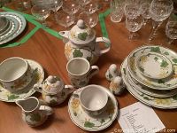 Tea set items including teapot, sugar bowl, creamer, cups, saucers, plates