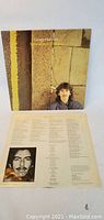 Front cover of George Harrison Somewhere in England album with inner lyric sleeve visible.