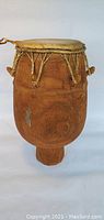 Full view of large drum showing wooden body with natural finish and skinned top.