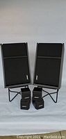 Front view of the pair of Bose 301 Series III speakers on metal stands with two smaller Bose swivel bookshelf speakers in front.