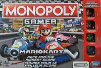 Front of Monopoly Gamer Mario Kart edition box showing Mario in racing kart and other characters.