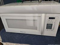 Front view of Magic Chef microwave showing door with vented window and handle