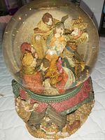 Detailed look at the nativity scene inside the globe with figurines of Mary, Joseph, baby Jesus, angels, and shepherds.