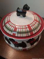 Close-up of lid showing the Scottie dog figurine handle and plaid pattern on the ceramic jar.
