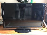 Front view of Sharp AQUOS 45 inch TV with black bezel and circular base stand