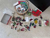 Photo showing a variety of colored glass Christmas ornaments along with a basket containing Christmas cards and other ornaments. Items are placed on a carpeted floor.