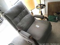 Front and side view of grey upholstered recliner chair with padded backrest and armrests with wooden frames.