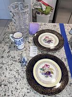 Photo showing lead crystal vase, blue and white Delft shoe figurine, Delft ceramic cup, two Steubenville collectible plates