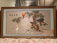 Full view of the silk thread embroidered Asian wall art framed with decorative gold trim and damaged glass in lower right corner, artwork size approximately 27x47 inches.