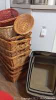 Stack of woven wicker baskets in various sizes and a round shallow wicker basket on top