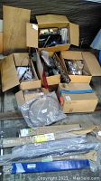 Six boxes containing various vehicle parts including wrapped rods and components, open and closed boxes showing collection of parts.