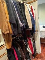 Photo of hanging women's clothing including jackets and sweaters in multiple colors and styles