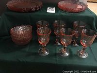4 bowls stacked on left and 6 salmon swirl glasses arranged in front