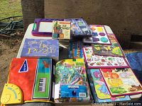 Overview of various children's toys including boxed TOT Tower game, Great Big Puzzle, musical piano mat, plastic toys in packaging, and a purple magnetic drawing board.