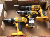 Two used DEWALT 20V Max cordless drills in a cardboard box, showing yellow and black build, variable speed trigger, torque ring and chuck, no batteries attached.