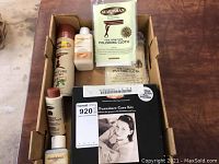 Top view of the Guardsman Furniture Care Kit showing several unopened cans, bottles, and cleaning cloths inside a box.