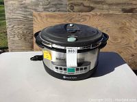 Closed pressure cooker with Russell Hobbs Nutritionist branding on stainless steel body and black lid featuring pressure valve and digital control panel.