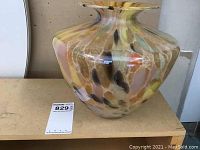 Large bulbous multicolor glass vase with wide opening shown from side angle.