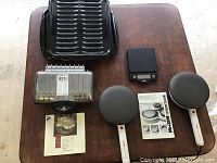 Photo showing UNO series electric Belgian waffle maker, two new black broiler pans, and OXO 5lb digital food scale on wooden table